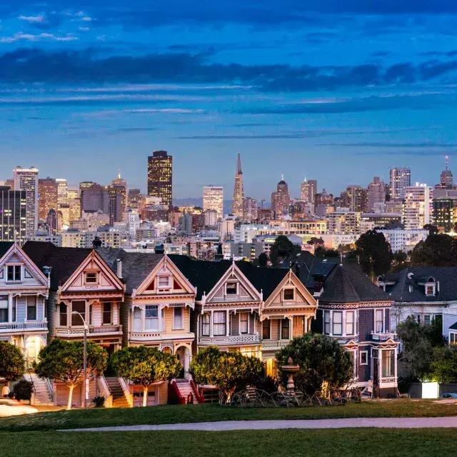 阿拉莫广场(Alamo Square)著名的彩绘女士们站在贝博体彩app日落时分的天际线前。.